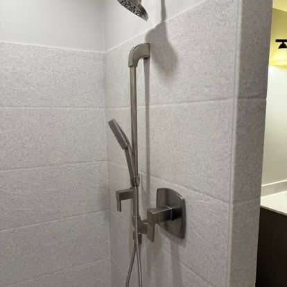 A tiled shower with new fixtures installed